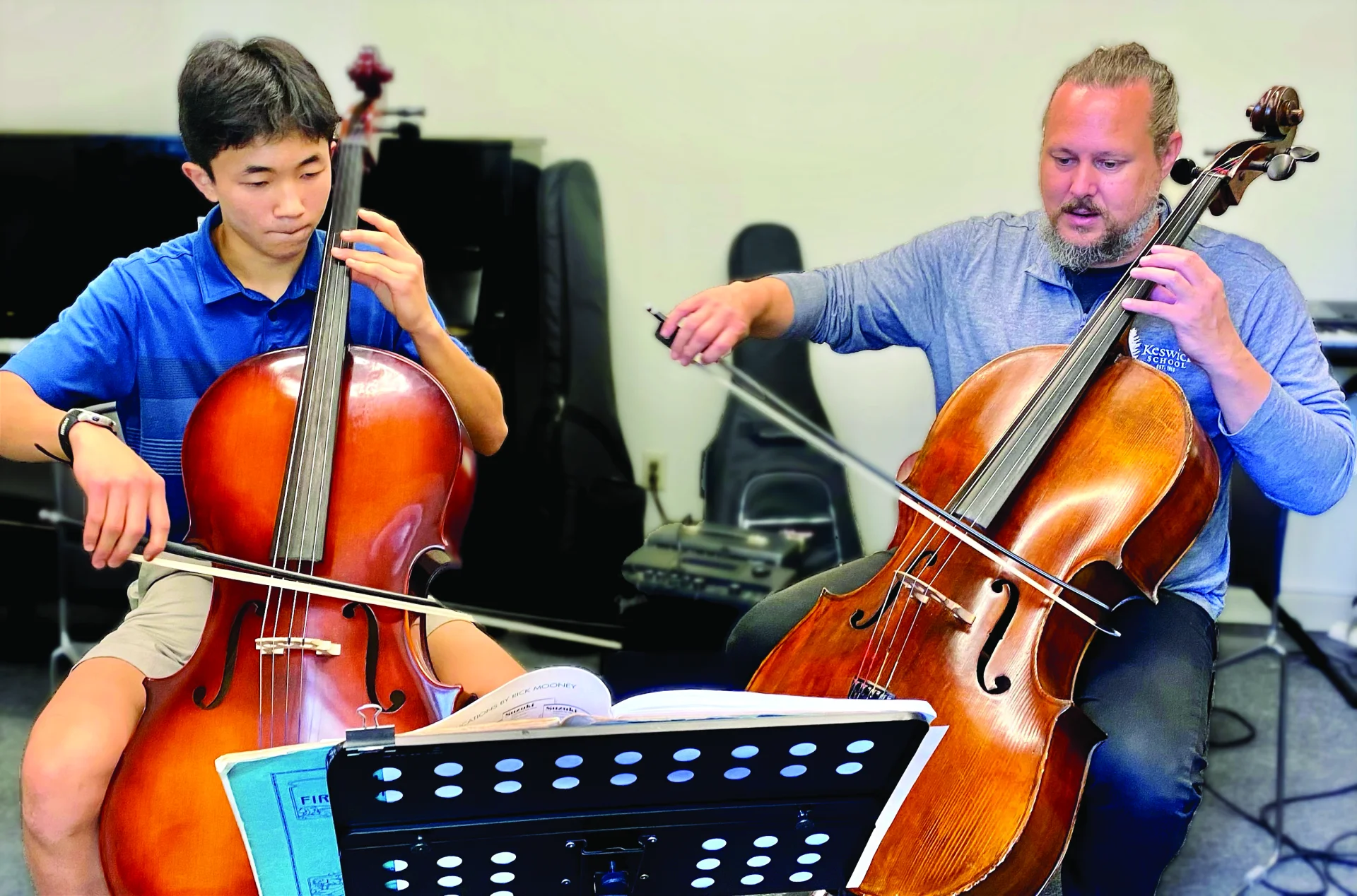 student and teacher playing cello